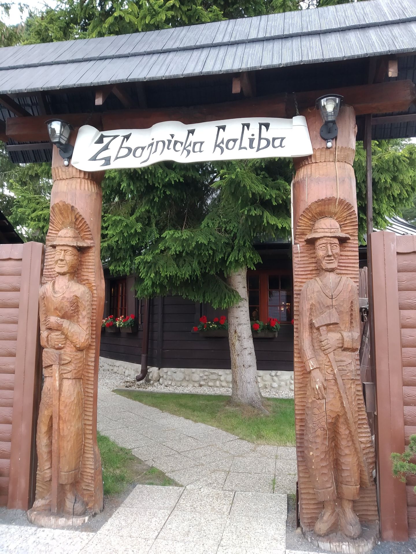Zbojnícka koliba – vstupná brána s vyrezávanými sochami